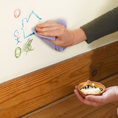 A person using Mayonnaise to clean marks off of a wall.