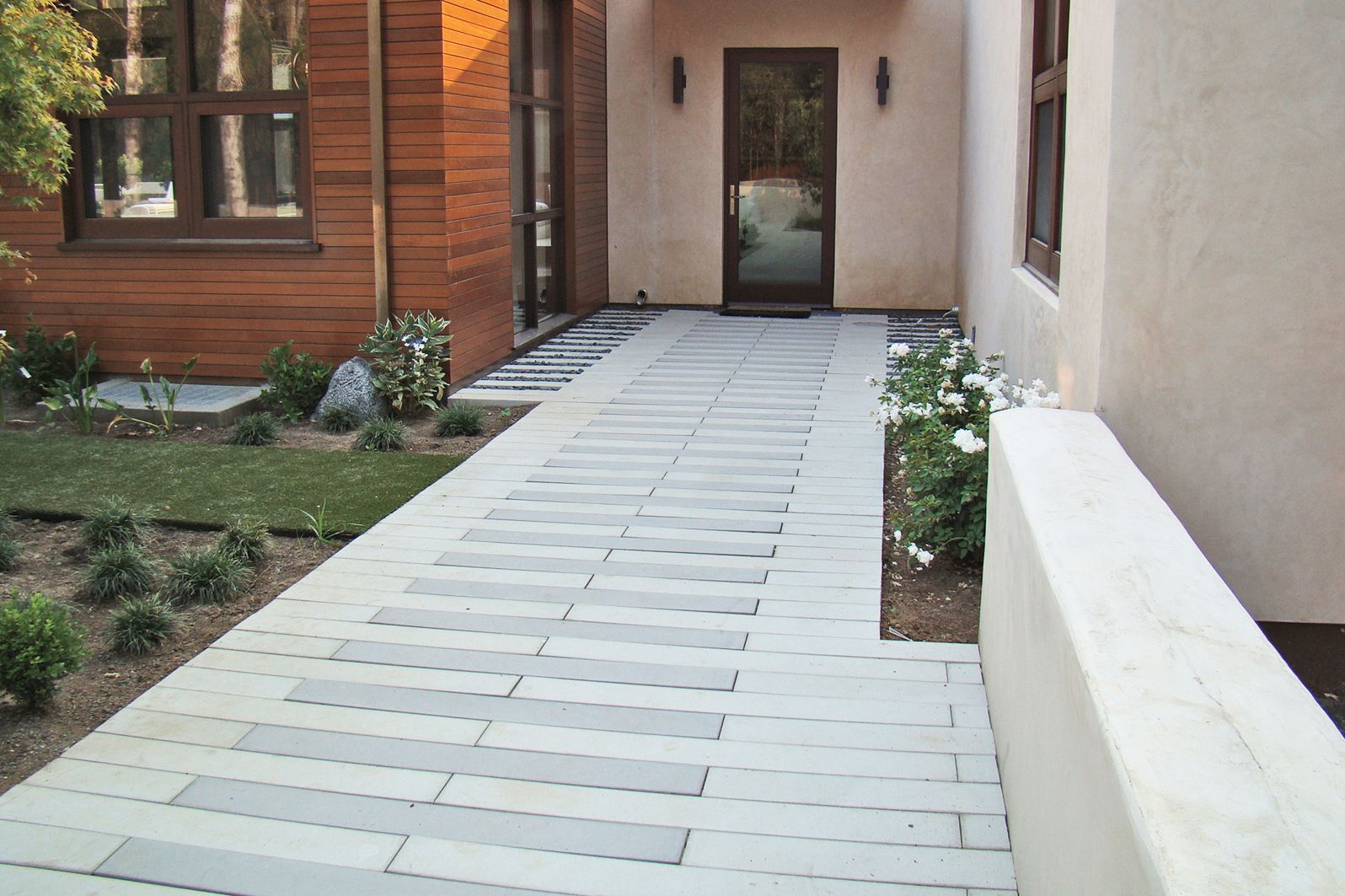 A DIY pathway to a house made of light and dark grey stones.