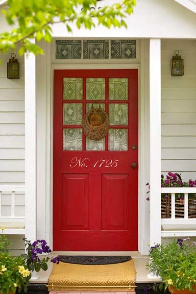 A red front door with the house number written in large letters.