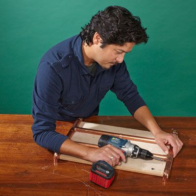 A man secures the fittings of a log holder.