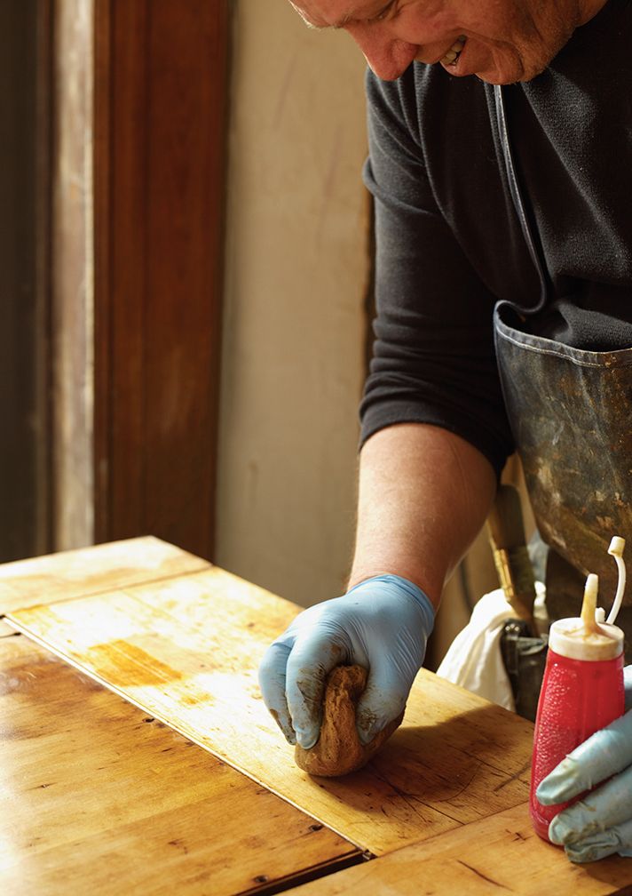 A man applies a new finish to his woodwork.