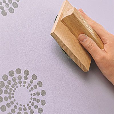 using the wall stamp to make designs on the painted wall