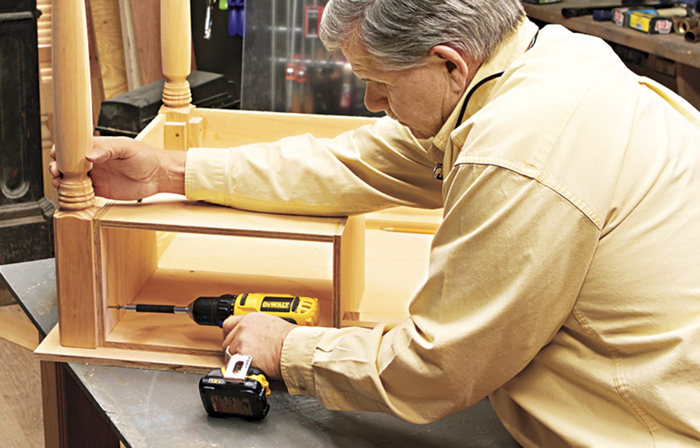 A man attaching a cubby to a desk.