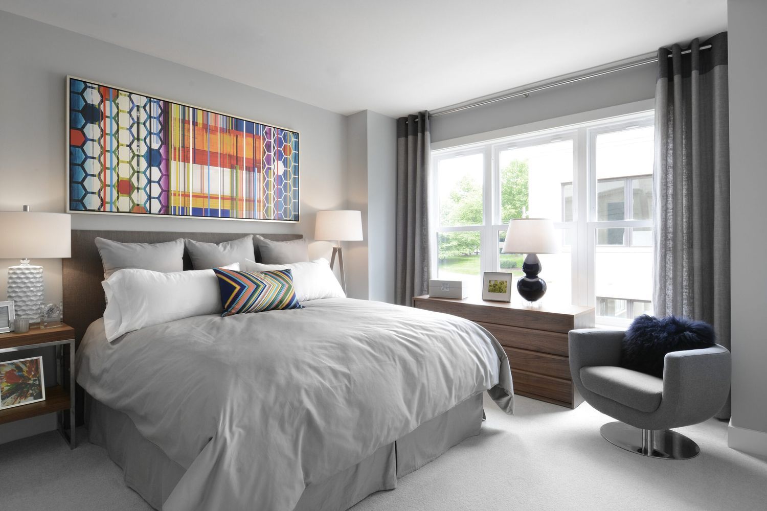 A bedroom with windows lining one of the walls.