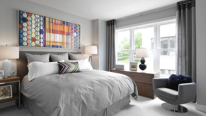 A bedroom with windows lining one of the walls.