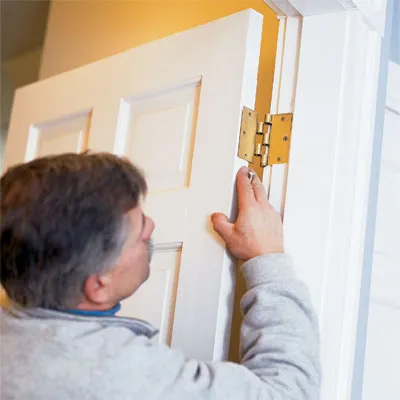 Tom Silva reattaches the door that will no long stick.