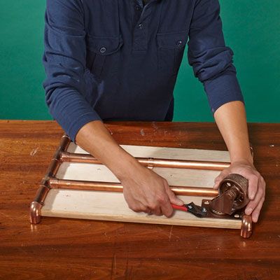 A man adds mobility to his log holder's caster.