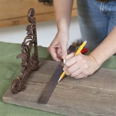 A woman marks the vintage tap locations for the towel rack.