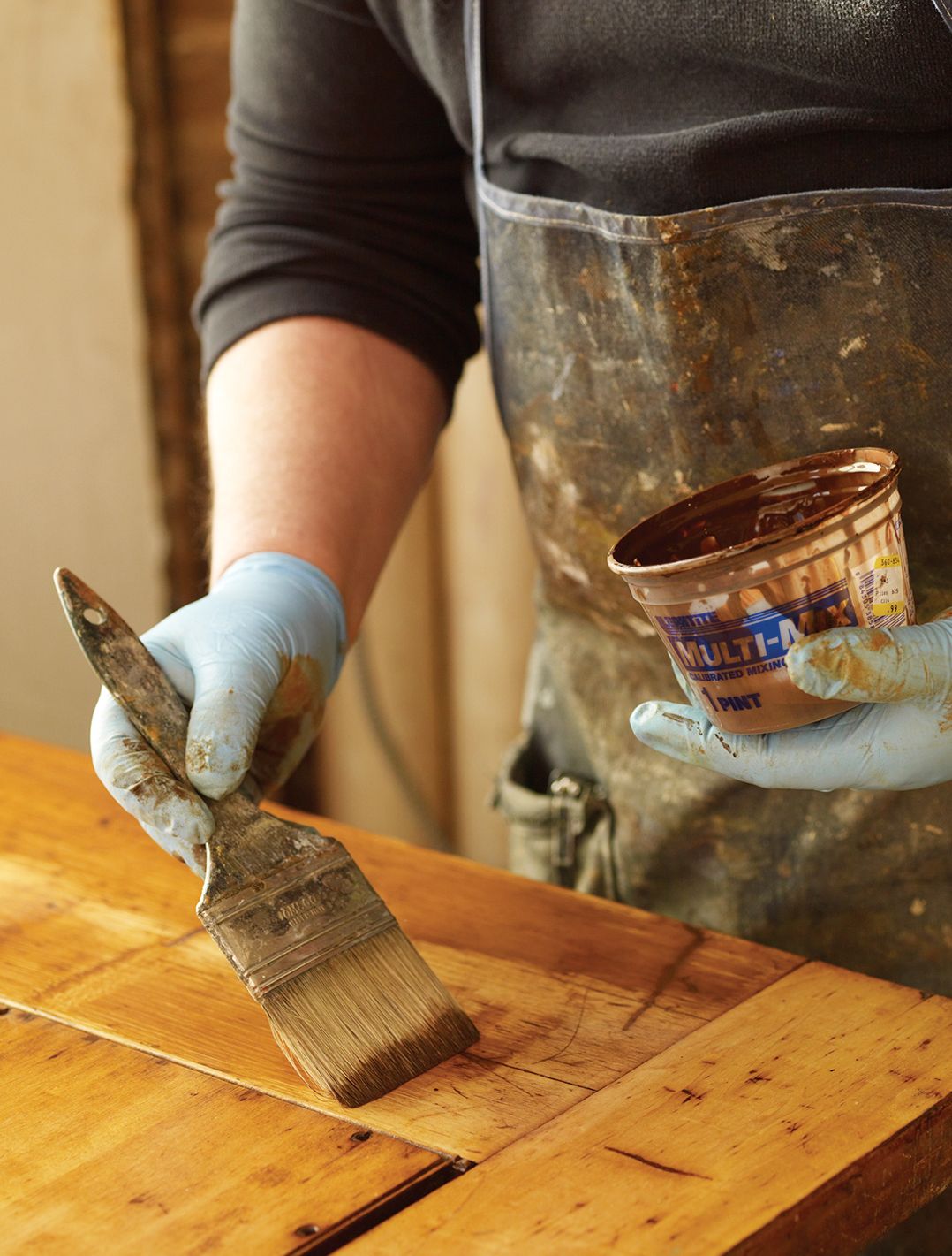 A man applies a top coat to his woodwork.