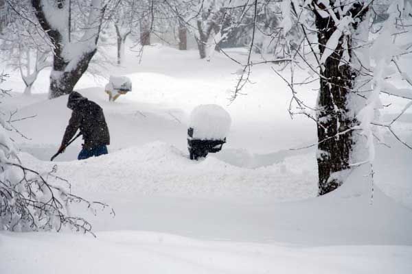 A man shoveling snow after a snowstorm.