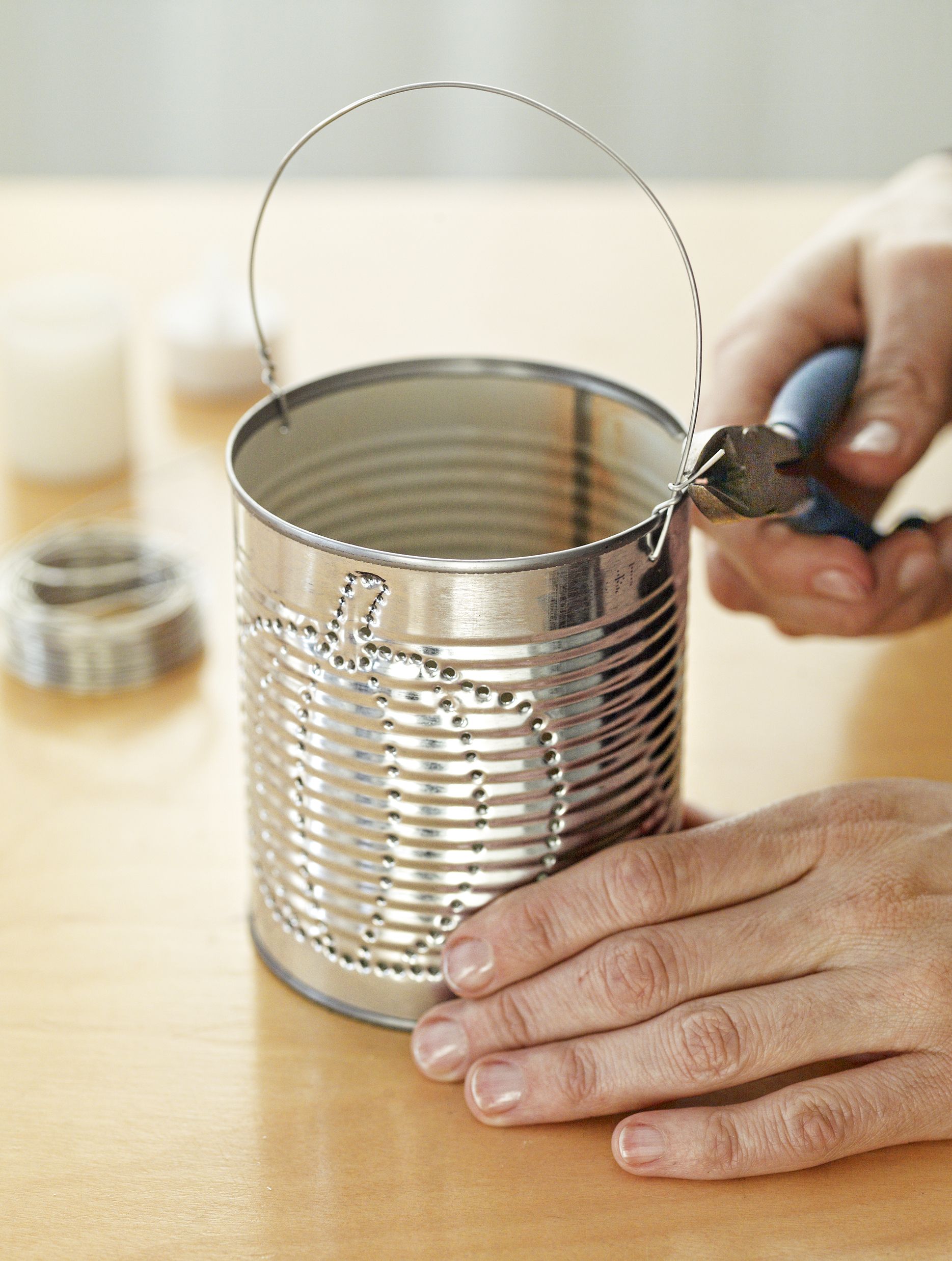 attaching a wire handle to the tin can lantern