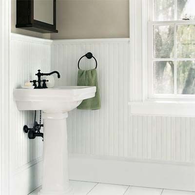 A bathroom redone with white wainscotting on the walls.