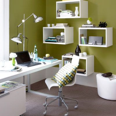 Modern home office with green walls, white floating shelves and all white details. 