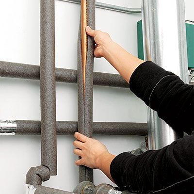 placing foam insulation around pipes to prevent them from freezing