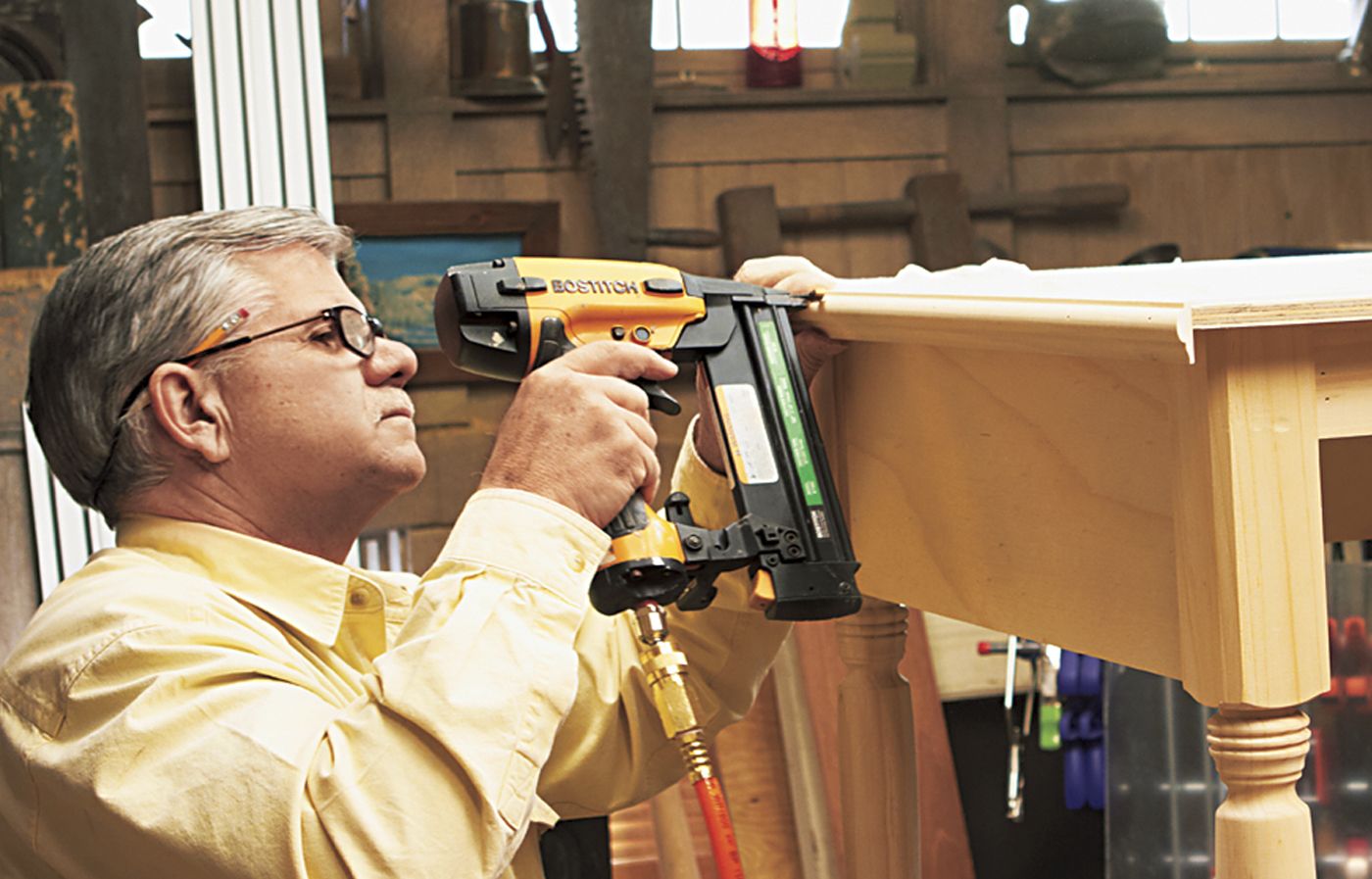 A man trimming the sides of a desk.