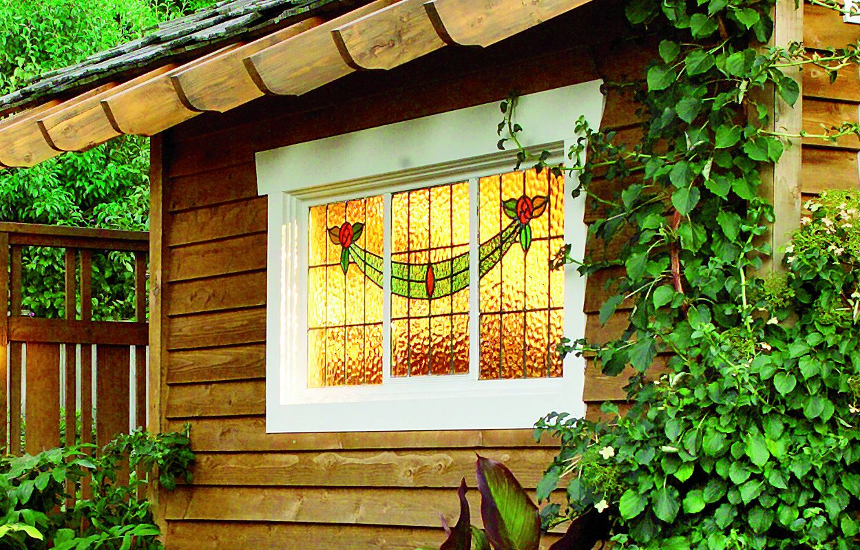 An Outdoor Dining Space with a stain glass window near by.