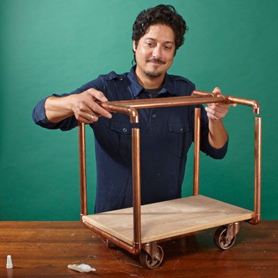 A man assembles the final structure of a log holder.