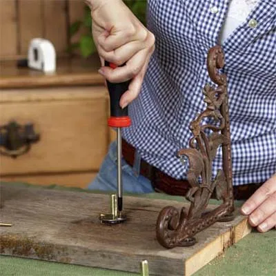 A woman attaches the spindles for the vintage tap towel hooks.