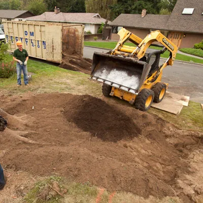 The basin, where the rain garden will go, is filled back in by the excavator.