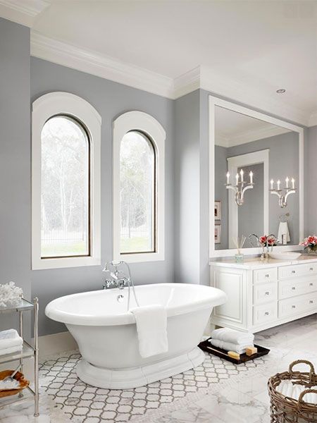 A tile rug underneath a grand bath tub