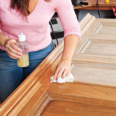 A person seals the wood of the door turned headboard.