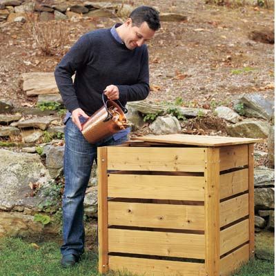 Person adding food scarps into a compost bin in the backyard.