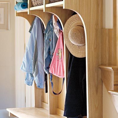 an up close view of a mudroom along a stairwell with hooks to hang clothes