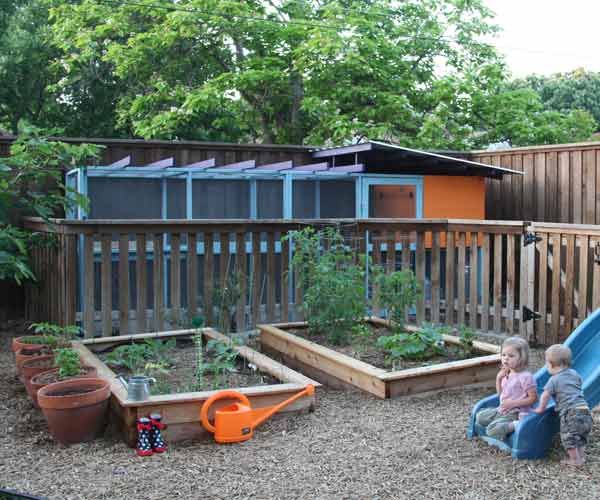 A well ventilated chicken coop near a garden.