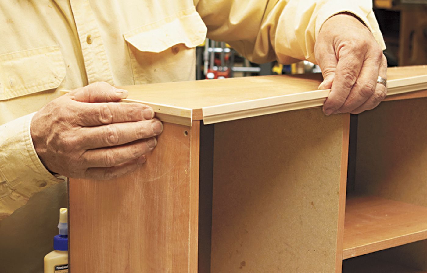 A man adding a hutch to a desk with a cubby.