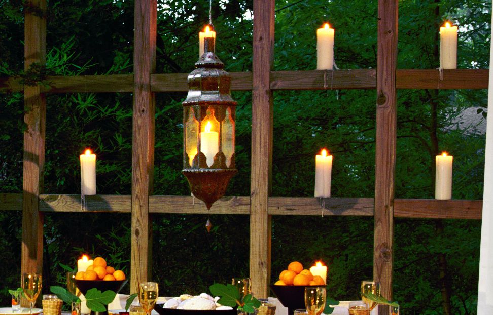 An outdoor dining space with a candle wall.