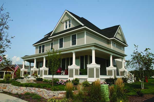 Image of a large home with an asphalt roof and green fiber-cement siding