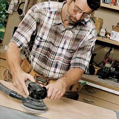 Norm Abram using a random orbit sander.