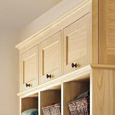 an up close look of a mudroom along a stairwell with cabinets at the top