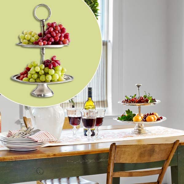 A pewter server sitting on the edge of a dining room table.