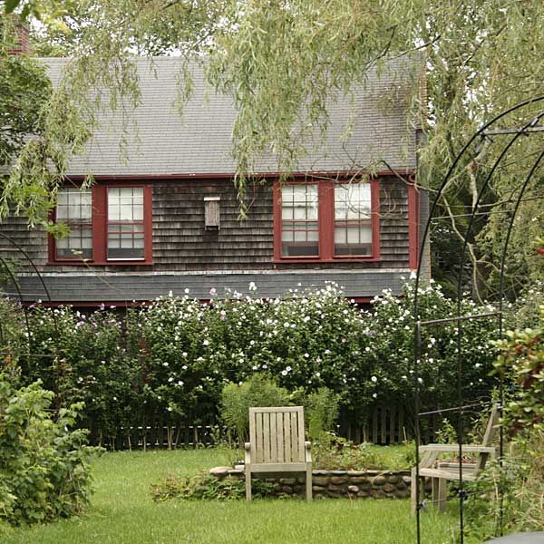 a romantic scene in a cottage garden with chairs