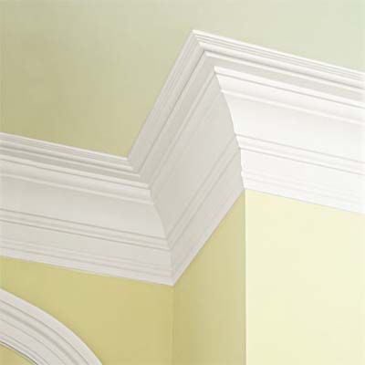 A yellow painted wall with crown molding.