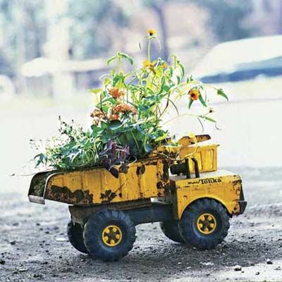 an old dump truck toy that is used a planter