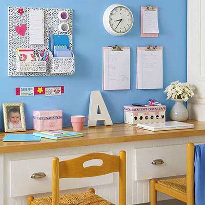 Children's study area with a blue wall and a wall mounted clock. 