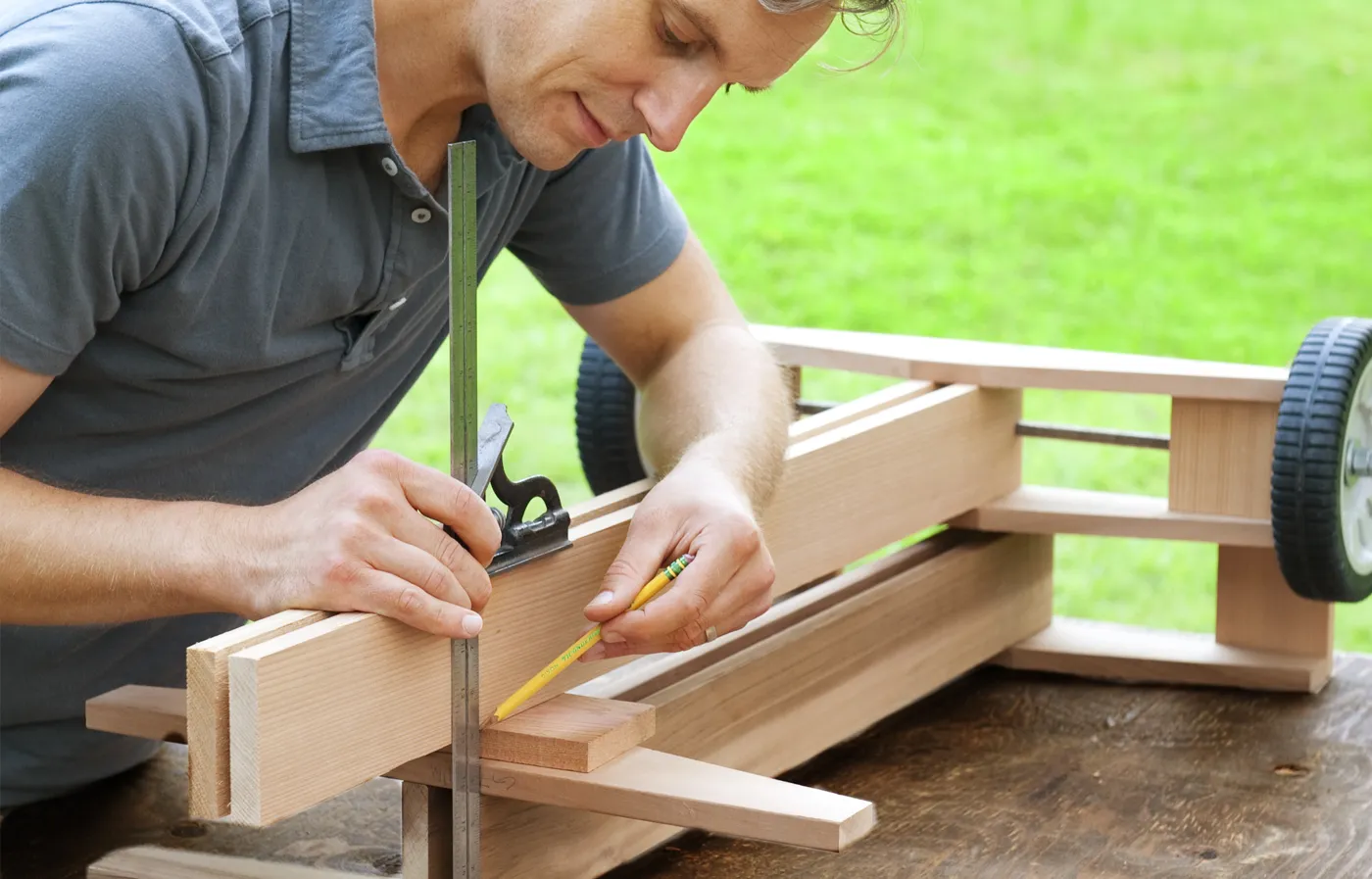 A person measuring and cutting the legs.