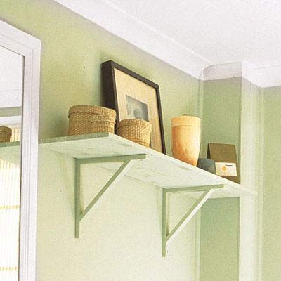 A floating shelf above a toilet in a bathroom.