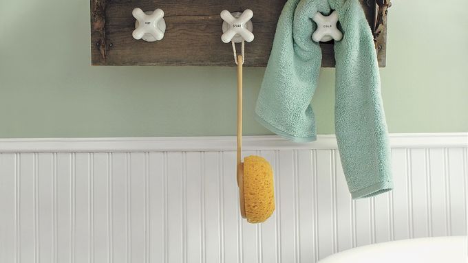 A DIY towel rack made using vintage taps as towel hooks.