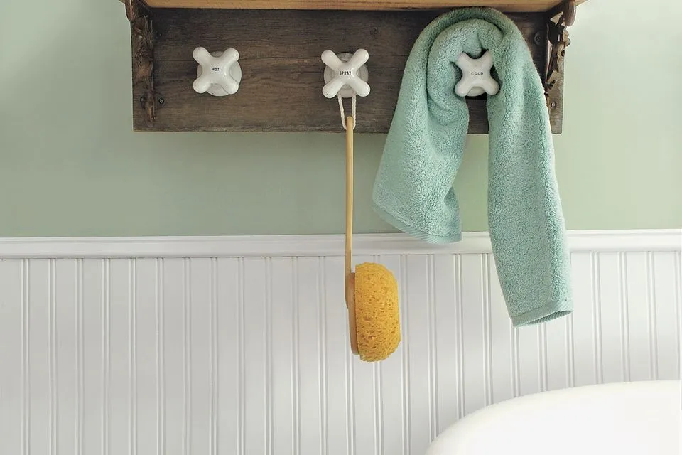 A DIY towel rack made using vintage taps as towel hooks.