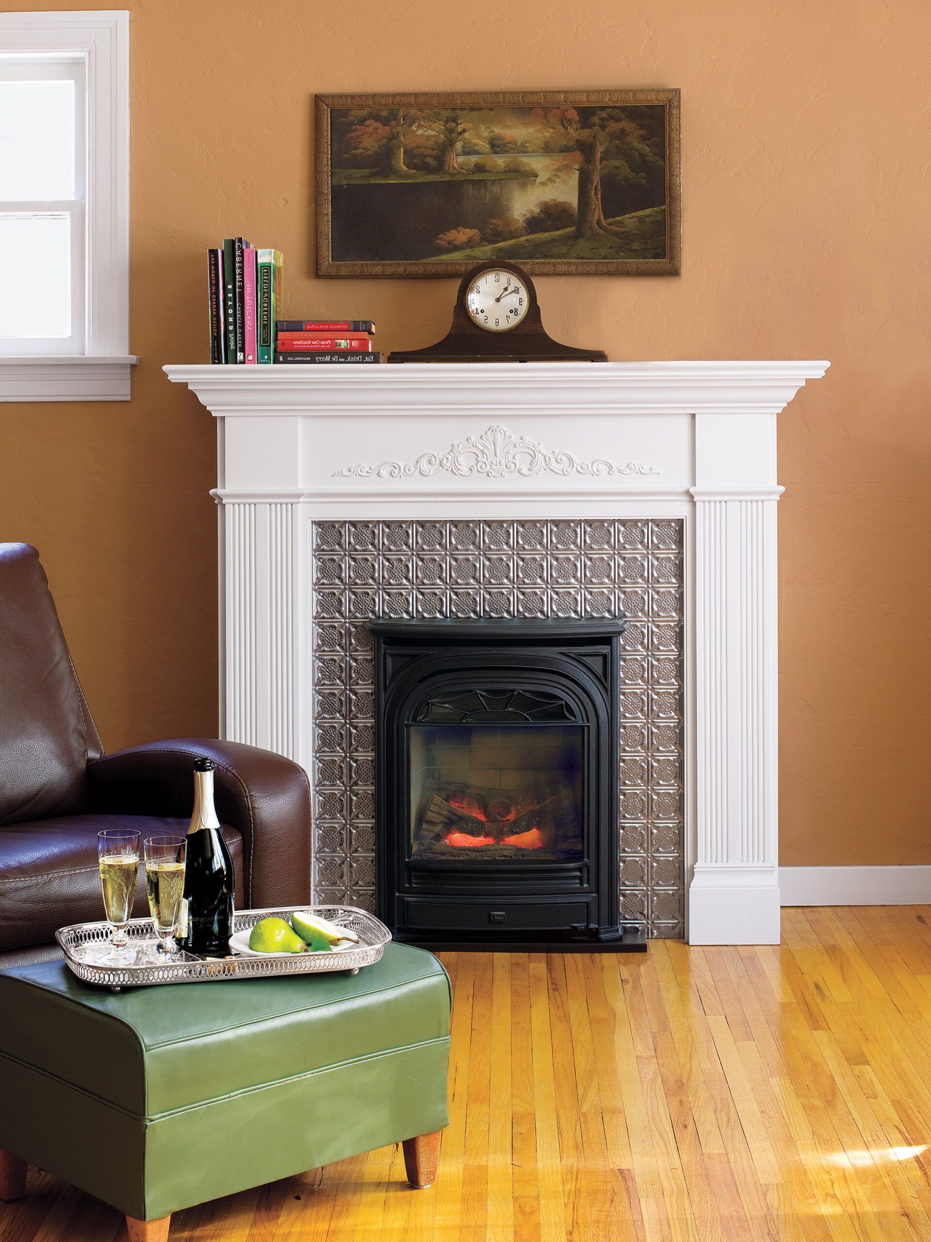 Image of a beautifully designed fireplace with a white mantel and decorative metal surrounding it 