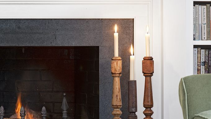 a candlestick made from a stair baluster next to a fireplace