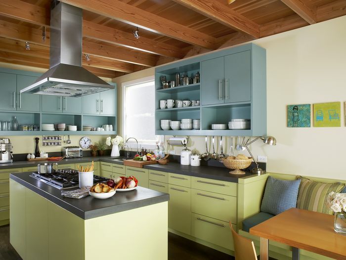 A kitchen with a vent hood over a stove.