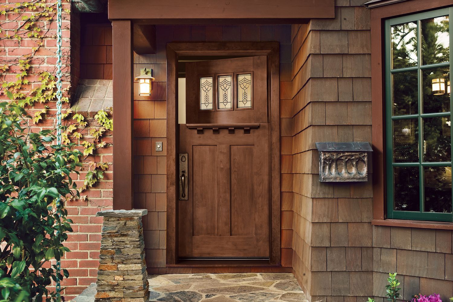 A fiberglass entry door with three small intricate glass windows and a shelf.