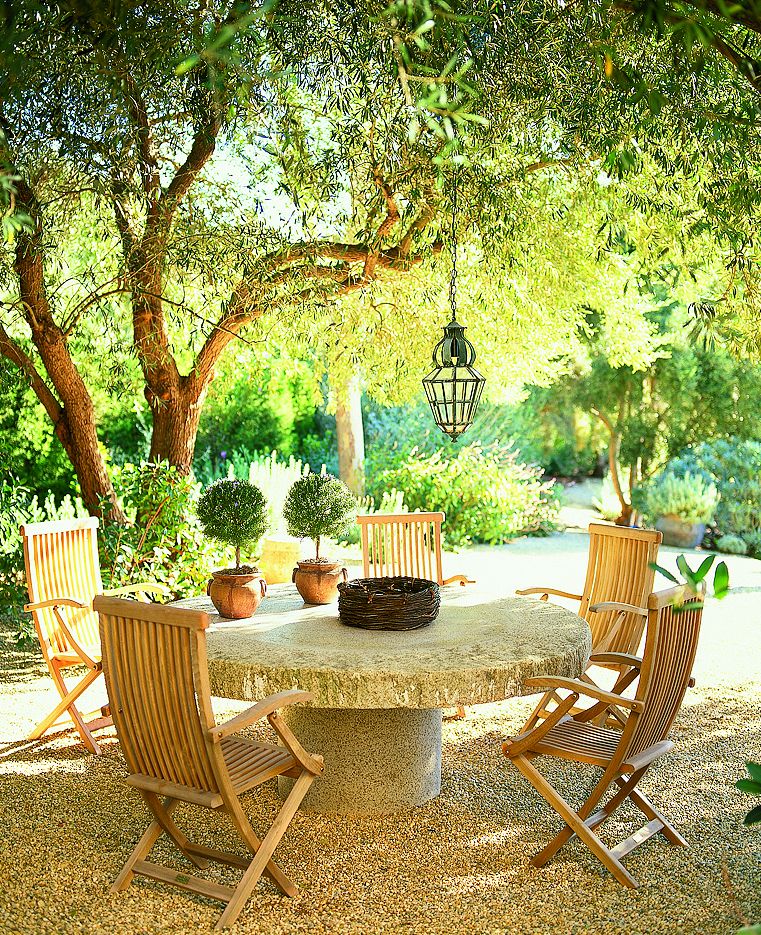 An outdoor dining space under a shade tree.