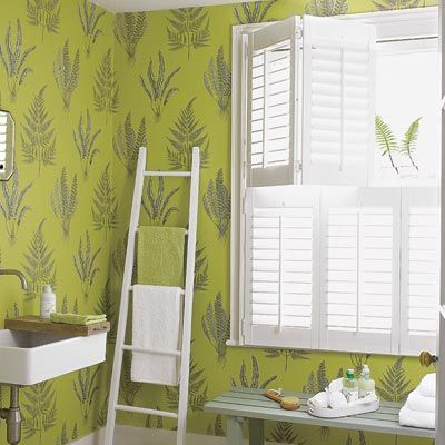 A bathroom with bright green patterned wallpaper that's washable.