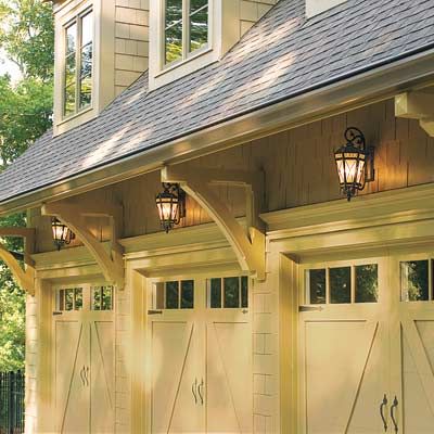 Three garage doors each with a light above it.