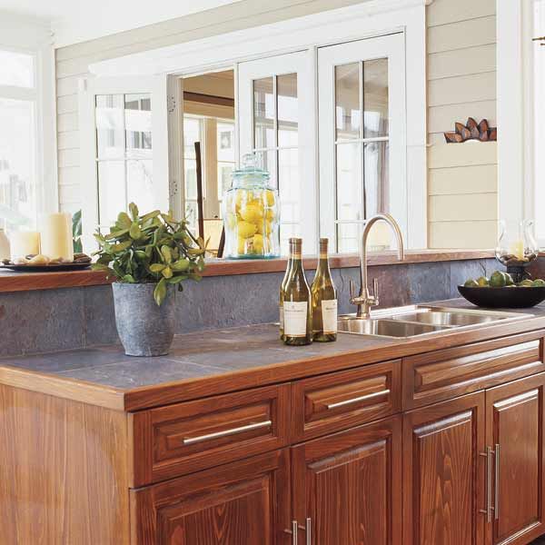 A small kitchen with stainless steel appliances, white cabinets, and a  natural light colored wood counter top Stock Photo - Alamy